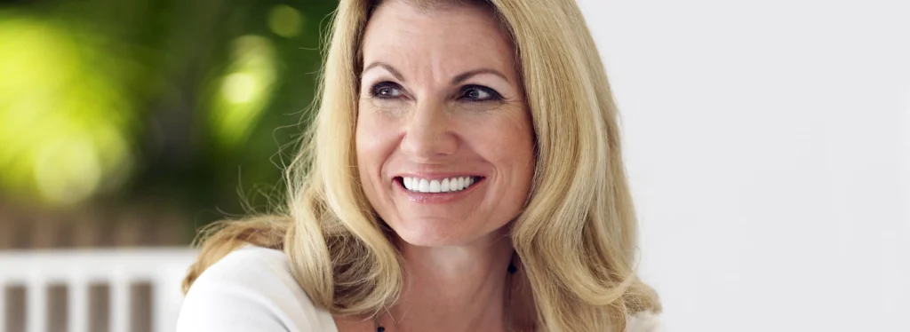 Smiling middle aged woman sitting on verandah and looking away